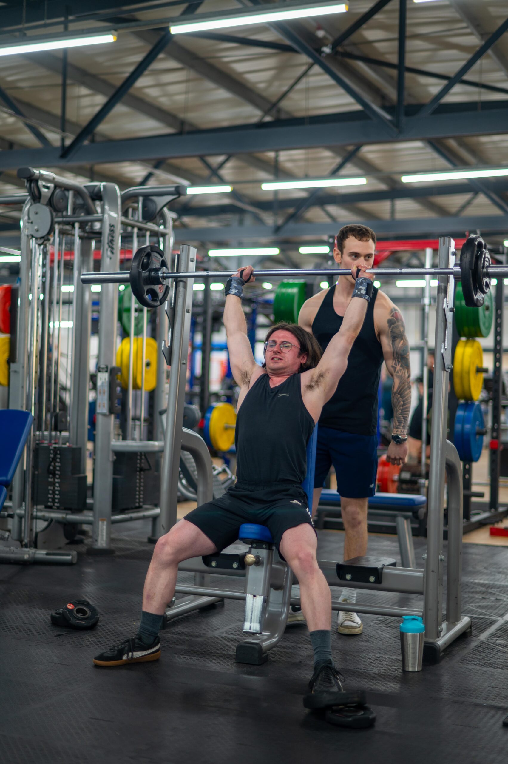 Refer a Friend - a man lifting a barbell in a gym