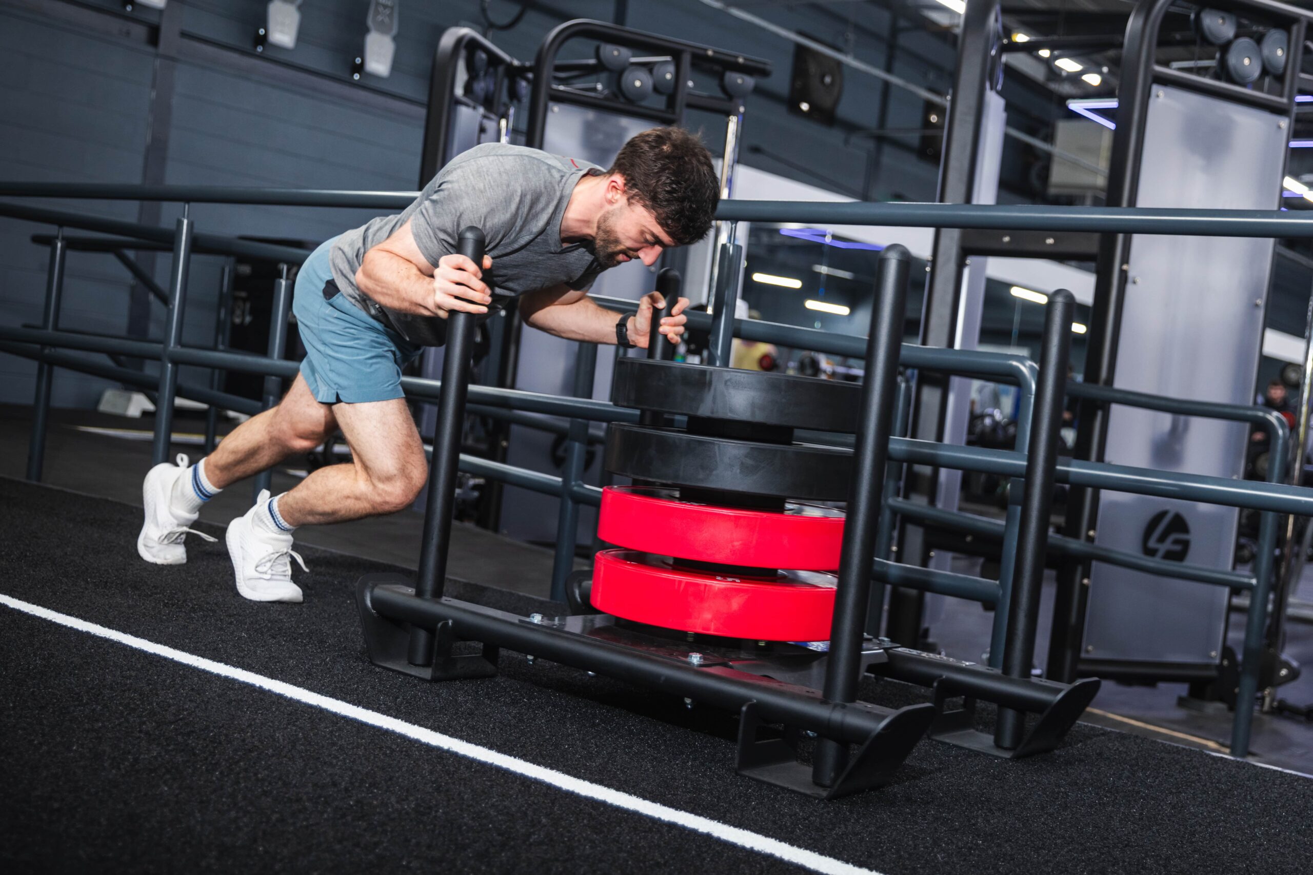 HYROX - man pusing a sledge in a gym