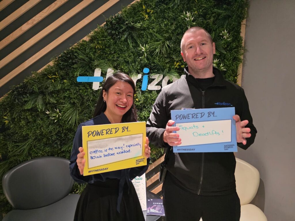Two people holding colourful signs.