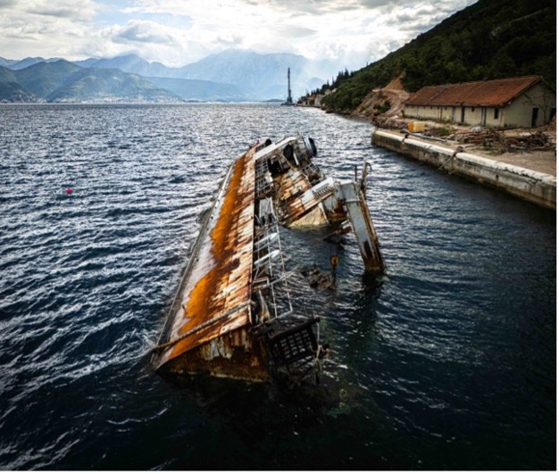 Rusty shipwreck partially submerged in water