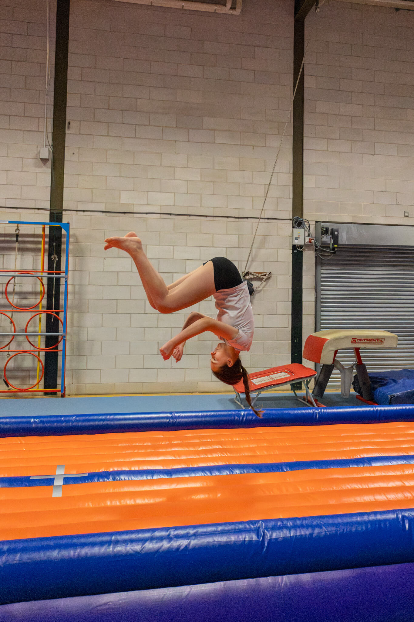 girl in the air tumbling on an inflatable track